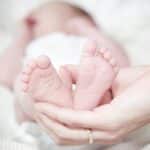 a baby's feet in a person's hands acupressure suitable for babies